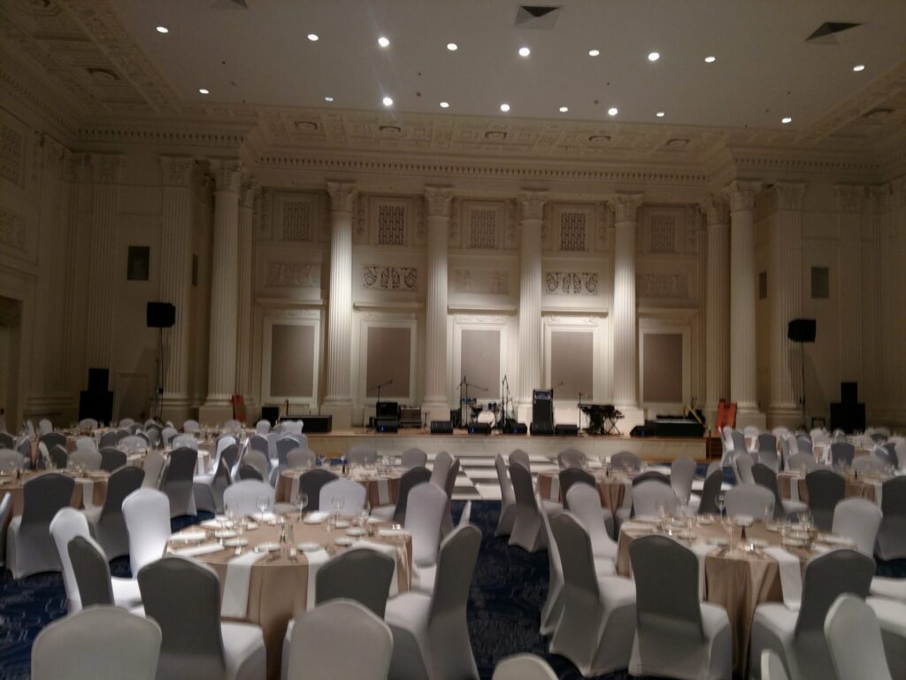 Ballroom set for a seated gala dinner with a band stage