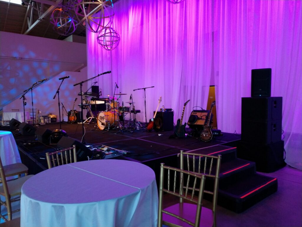 Band stage set for an evening gala under purple wash lighting