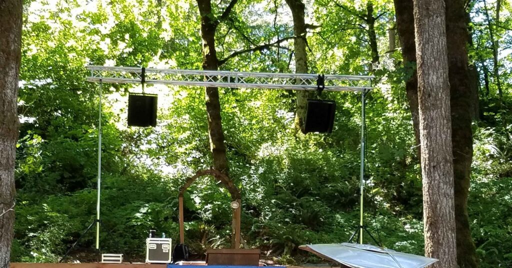 Vineyard stage with speakers hung from an overhead truss